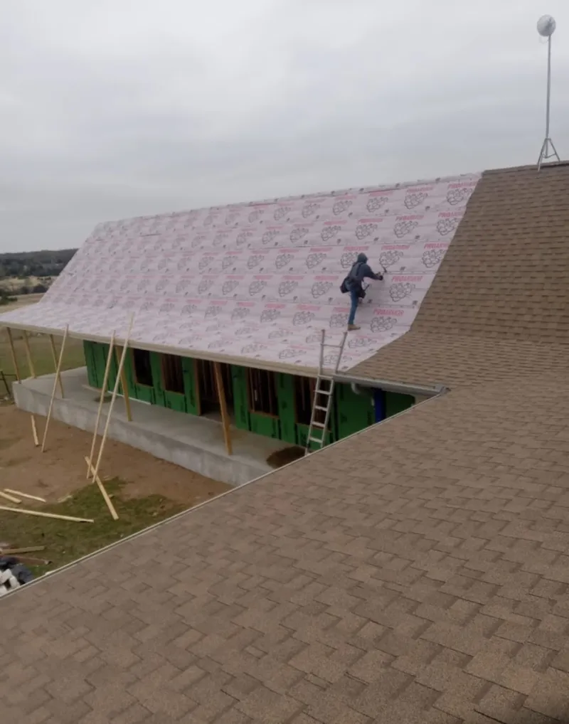 Worker preparing underlayment for a metal roof installation in Connellsville